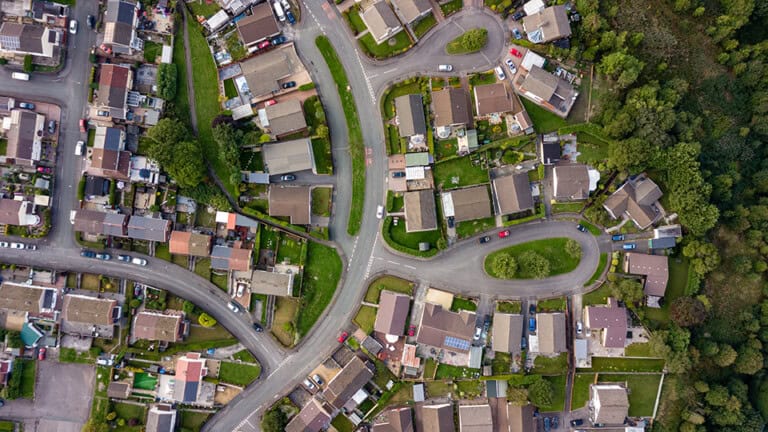 Birds-eye view of housing estate beside a forest