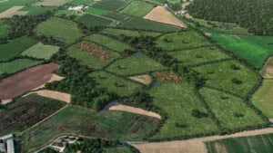 Birds-eye render of Chippenham Habitat Bank with habitats restored, including new meadows, hedgerow, trees, ditches, ponds, rivers, scrub, culvert, and broadleaved woodland