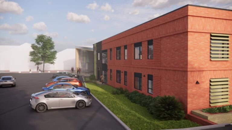 Visual render of the new school block, a 2-storey red brick building with a small car park in front.