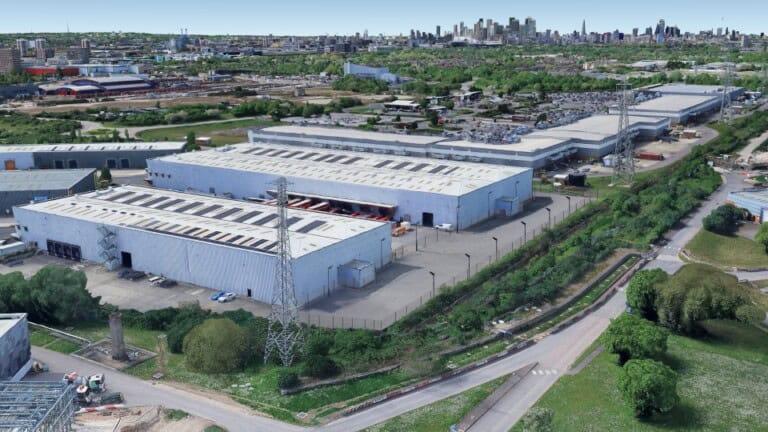 Aerial image of Gemini Business Park, two large warehouses surrounded by hedges and roads in an urban area with the London skyline on the horizon.