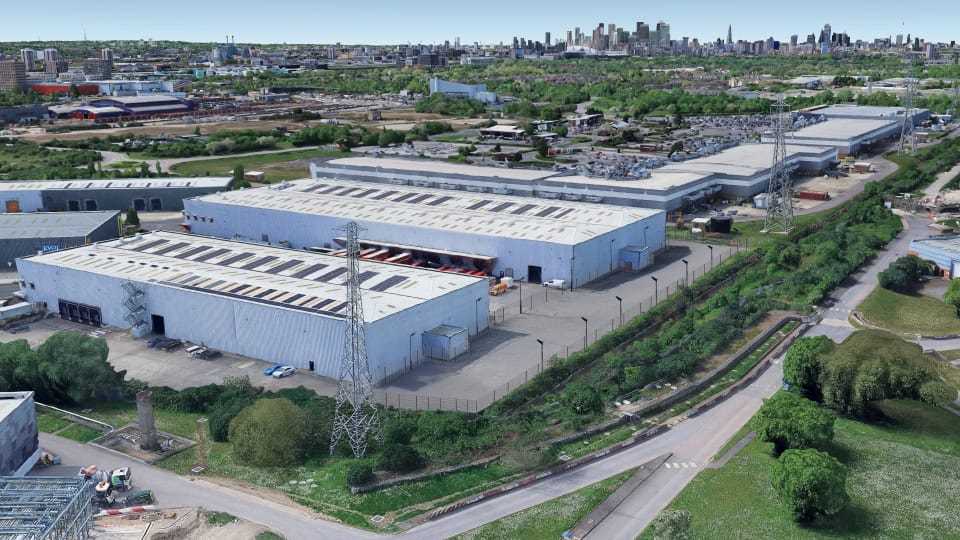 Aerial image of Gemini Business Park, two large warehouses surrounded by hedges and roads in an urban area with the London skyline on the horizon.